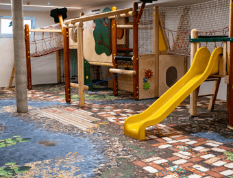 Indoor Spielplatz mit individuell bedrucktem FOTOBODEN™ im Märchenwald-Design auf dem Euroflex Fallschutzsystem von Kraiburg.