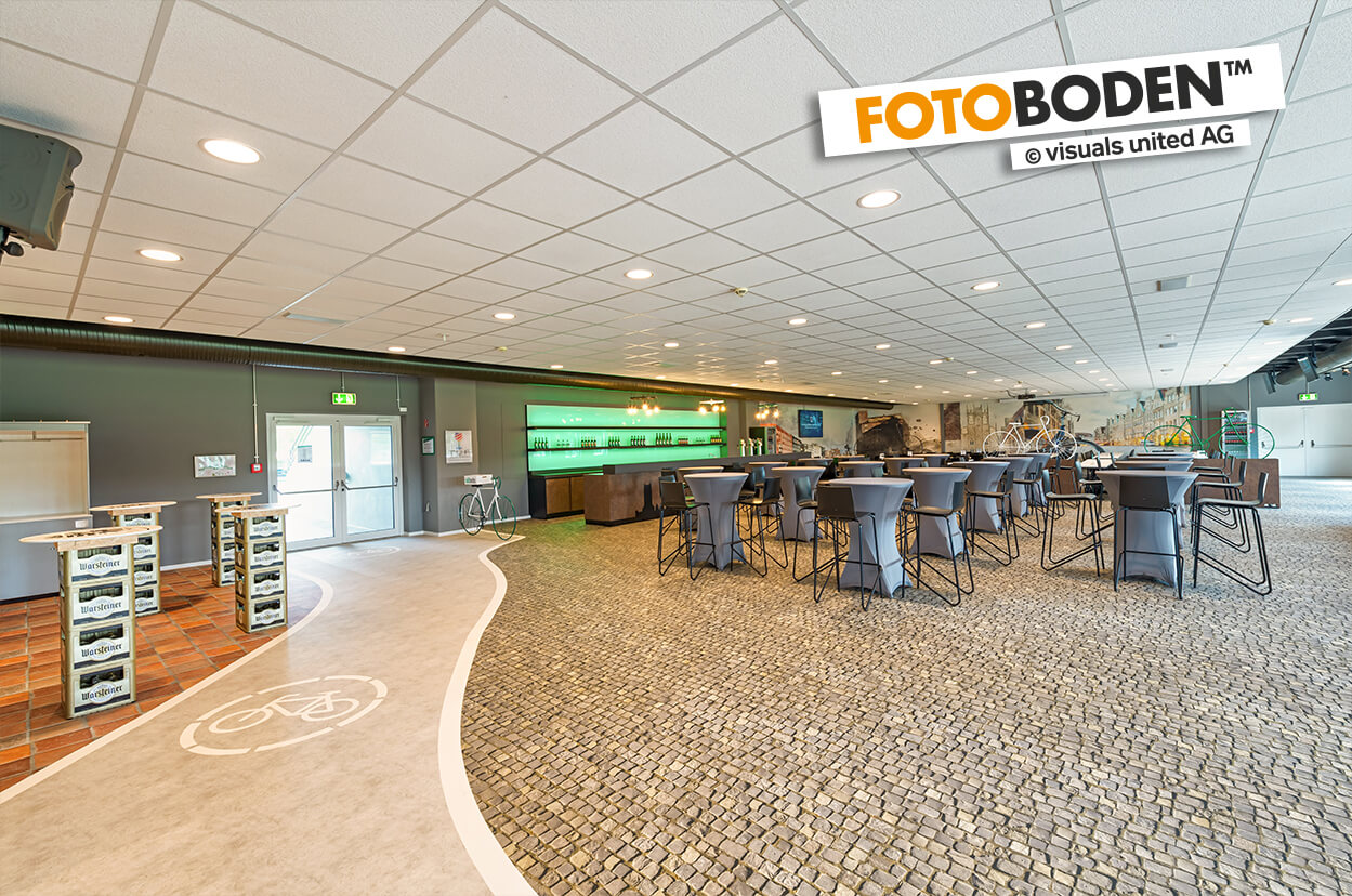 VIP Tribüne im Preussen Stadion mit FOTOBODEN™ in Objektqualität ausgestattet. Fahrradweg und Kopfsteinpflaster wurden individuell auf den Vinylboden gedruckt.